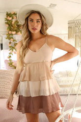 A tan color block mini dress with thin straps,  featuring a tiered skirt.”